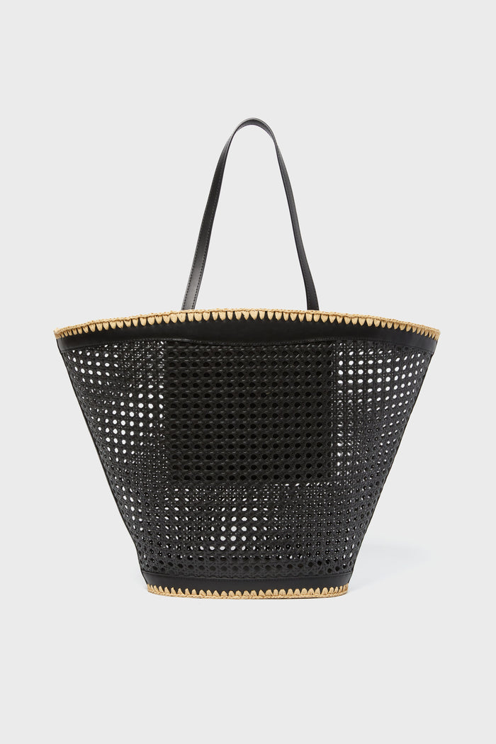 A black perforated BTB Ellie Tote with two handles and tan trim at the top and bottom—perfect for adding a boho-chic accent to any outfit.