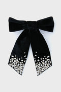 The Mignonne Gavigan black velvet hair bow features two ribbon tails with clusters of clear rhinestones at the ends—an elegant accessory to add sparkle and style to your look.