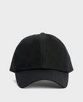 A Barbour black waxed cotton cap with a timeless look and water-resistant finish is displayed in a neutral, minimal setting.