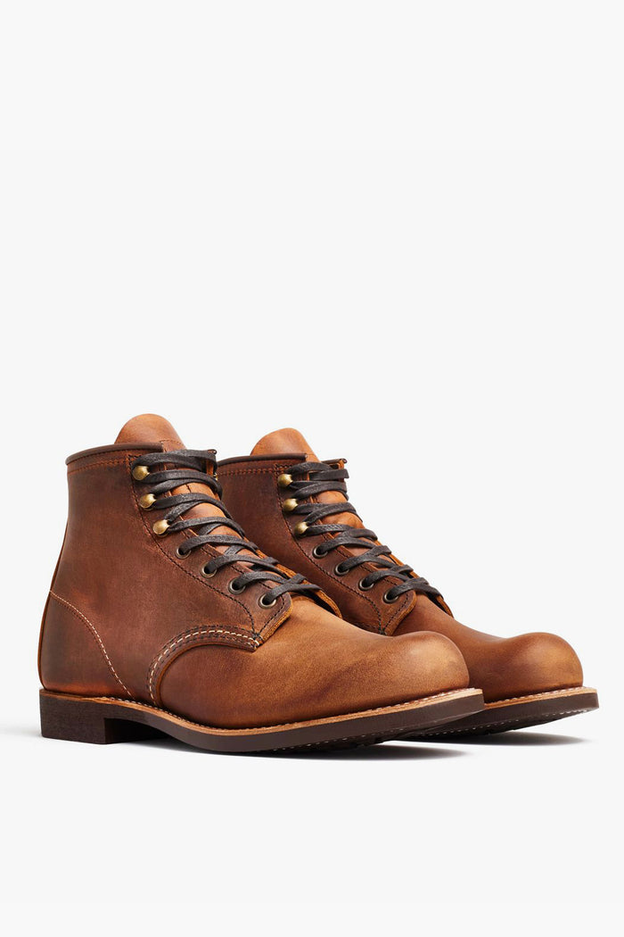 A pair of brown leather lace-up work boots with dark laces and metal eyelets from Red Wing Shoes, featuring classic heritage style.
