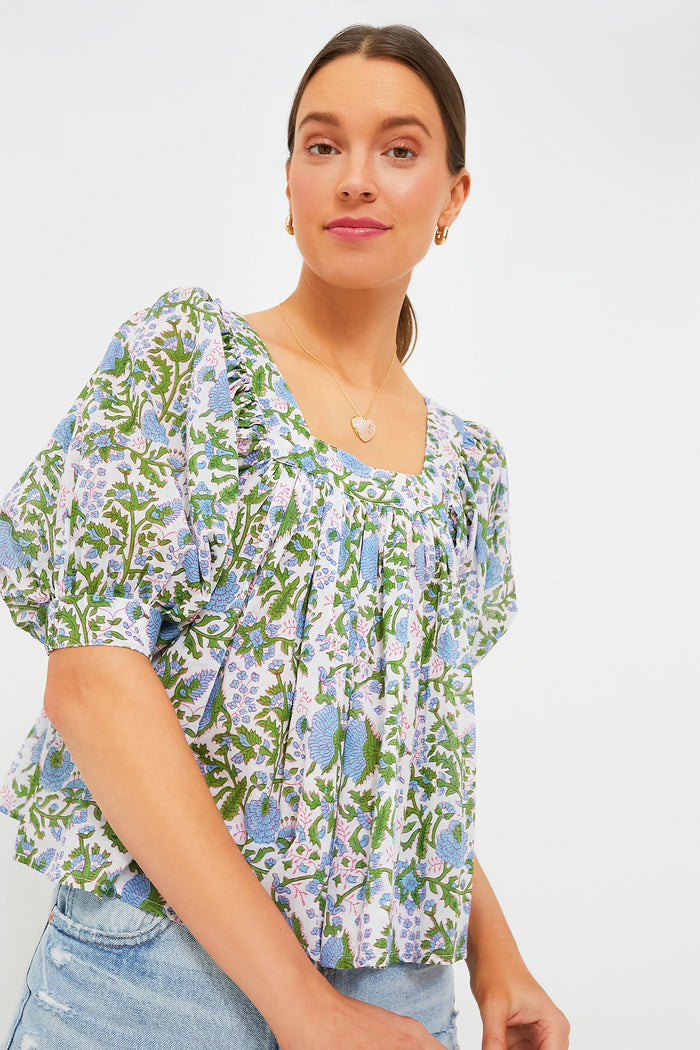 A woman models a stylish SZ Blockprints top with puffed sleeves and a floral block print, paired with light blue denim jeans.