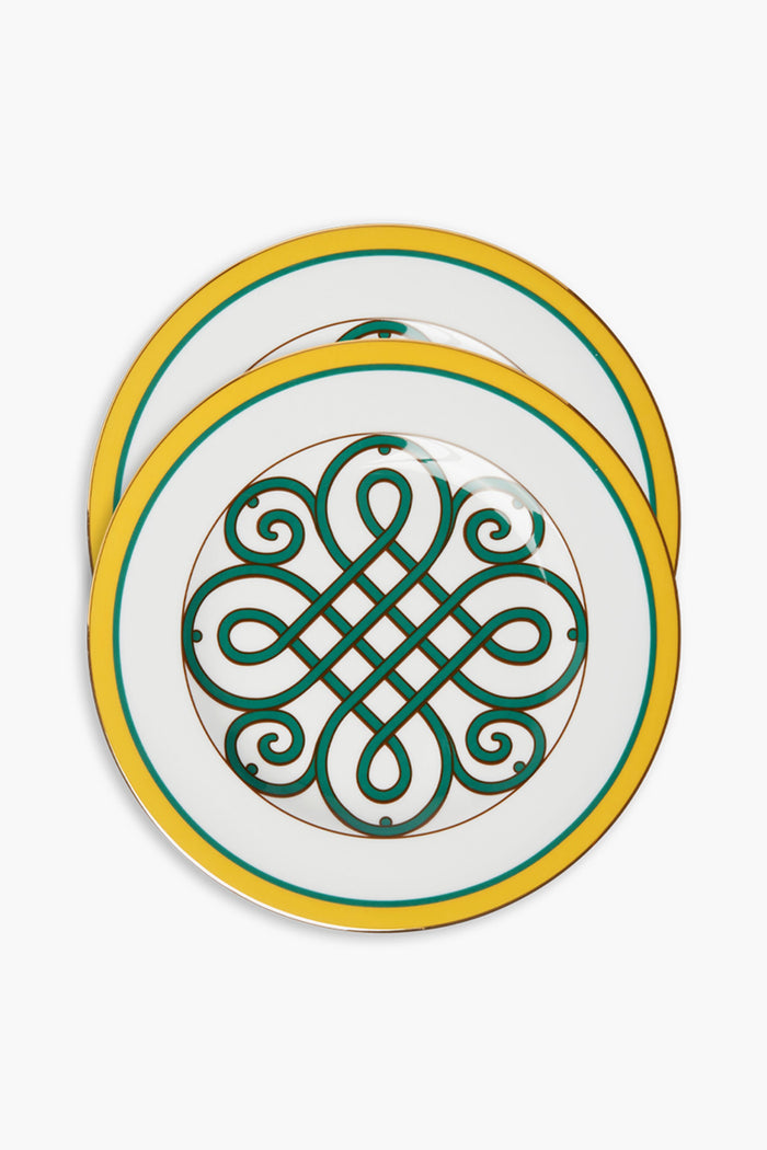 A pair of white Italian porcelain dinner plates by La DoubleJ, each with yellow and green borders, an intricate green and gold geometric center, and one plate featuring an elegant 18k gold rim overlapping the other.