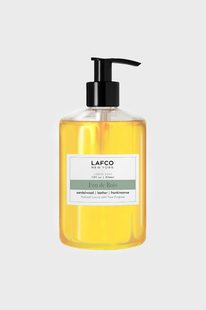 LAFCO New York’s sulfate-free Feu de Bois liquid soap in a clear pump bottle boasts sandalwood, leather, and frankincense notes—ideal for luxury candle lovers.