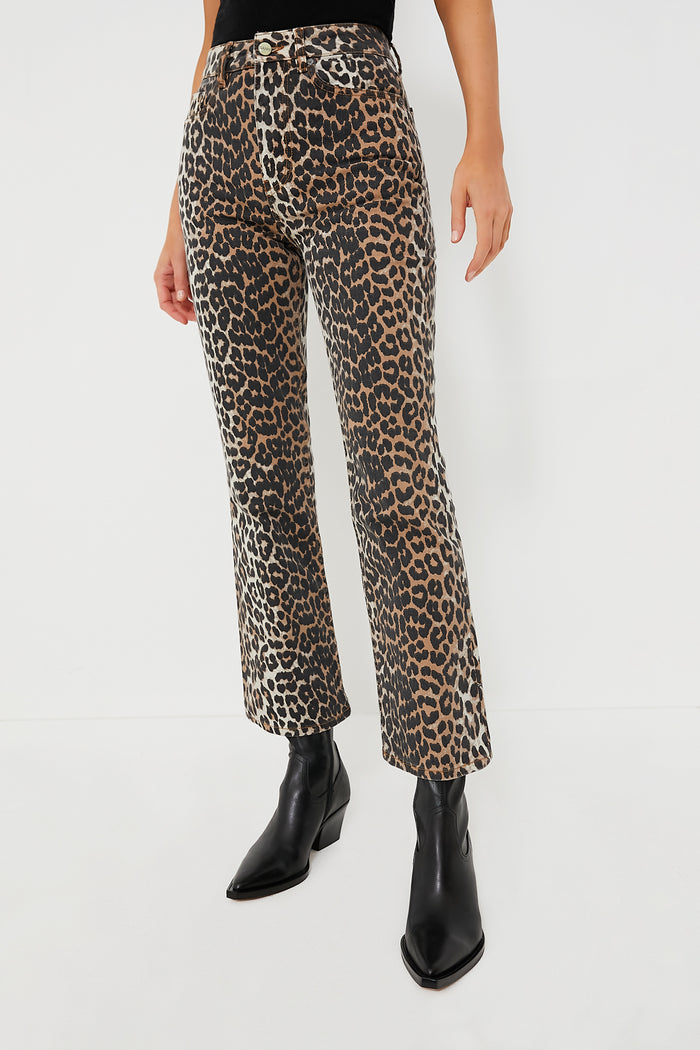A person wears GANNI high waist cropped leopard print denim pants with black pointed-toe boots.