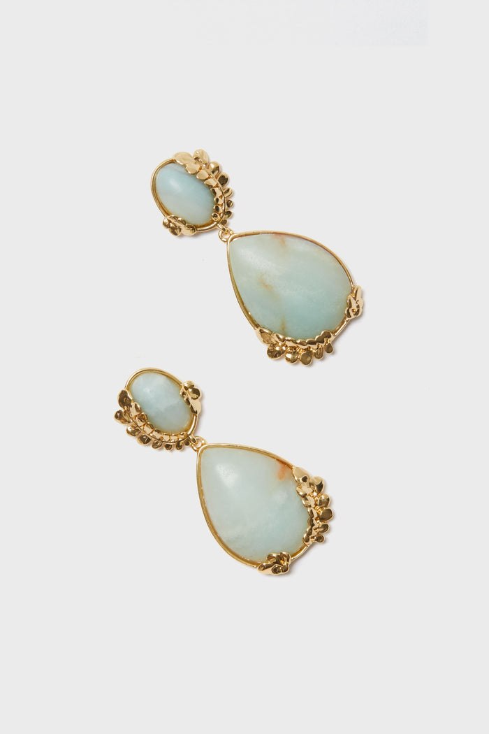 Mignonne Gavigan gold-plated teardrop dangle earrings with large and small light blue stones set in irregular gold frames, adorned with decorative clusters.