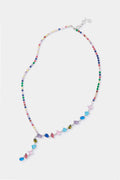 The Petit Moments Multi Colette Necklace features multicolored beads and assorted gemstones in vibrant shapes, creating a colorful crystal statement piece.