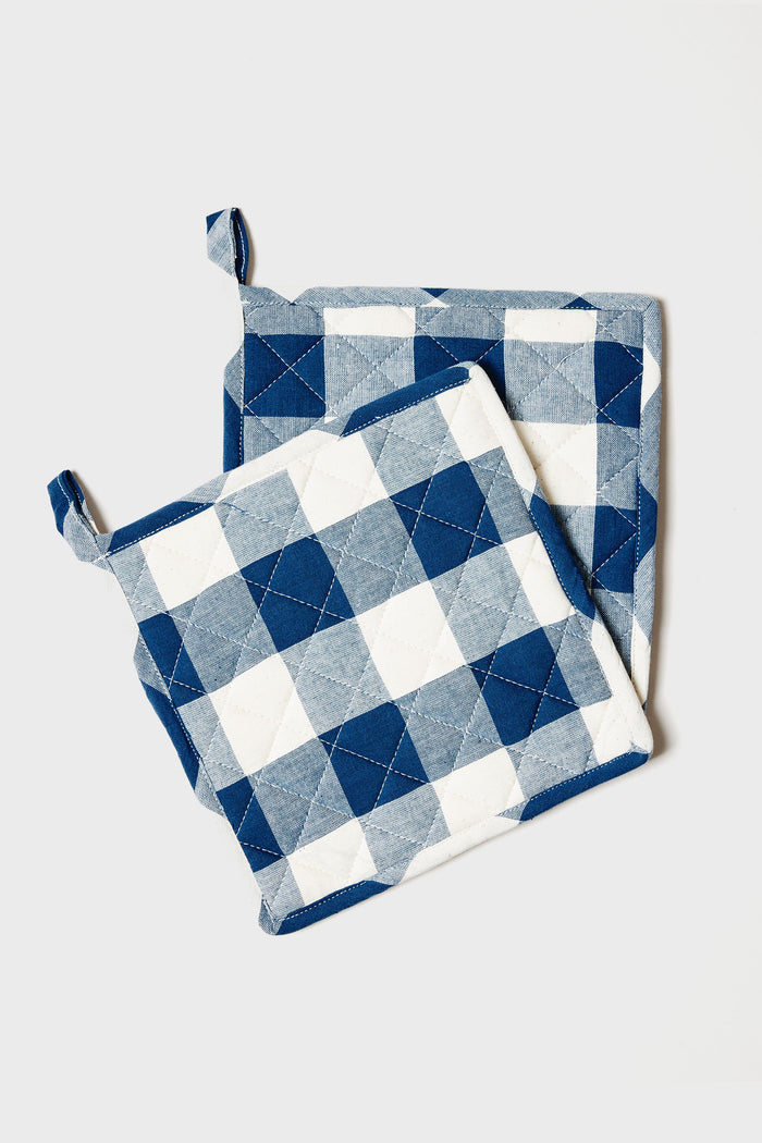 Two quilted potholders from Farmhouse Pottery, Inc feature a blue, white, and gray checkered pattern and are shown overlapping—perfect for adding a touch of farmhouse charm to your kitchen.