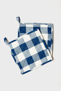 Two quilted potholders from Farmhouse Pottery, Inc feature a blue, white, and gray checkered pattern and are shown overlapping—perfect for adding a touch of farmhouse charm to your kitchen.
