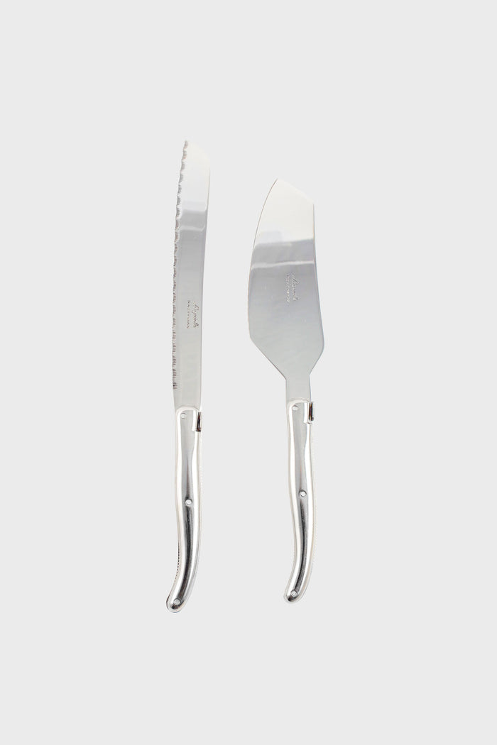 A Laguiole silver bread knife and cheese knife with matching curved handles are placed side by side, highlighting the brand's French craftsmanship and elegant design.