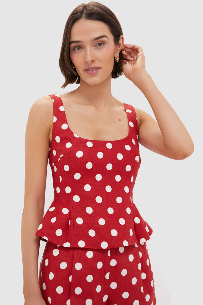 A woman wears a POSSE sleeveless red peplum-hem top with matching white polka dot pants, creating a stylish coordinated ensemble.