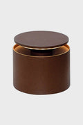 A round, brown, cylindrical Zafferano container with a matching flat lid and metallic interior is perfect for storing a rechargeable battery or parts of a dimmable LED table lamp.
