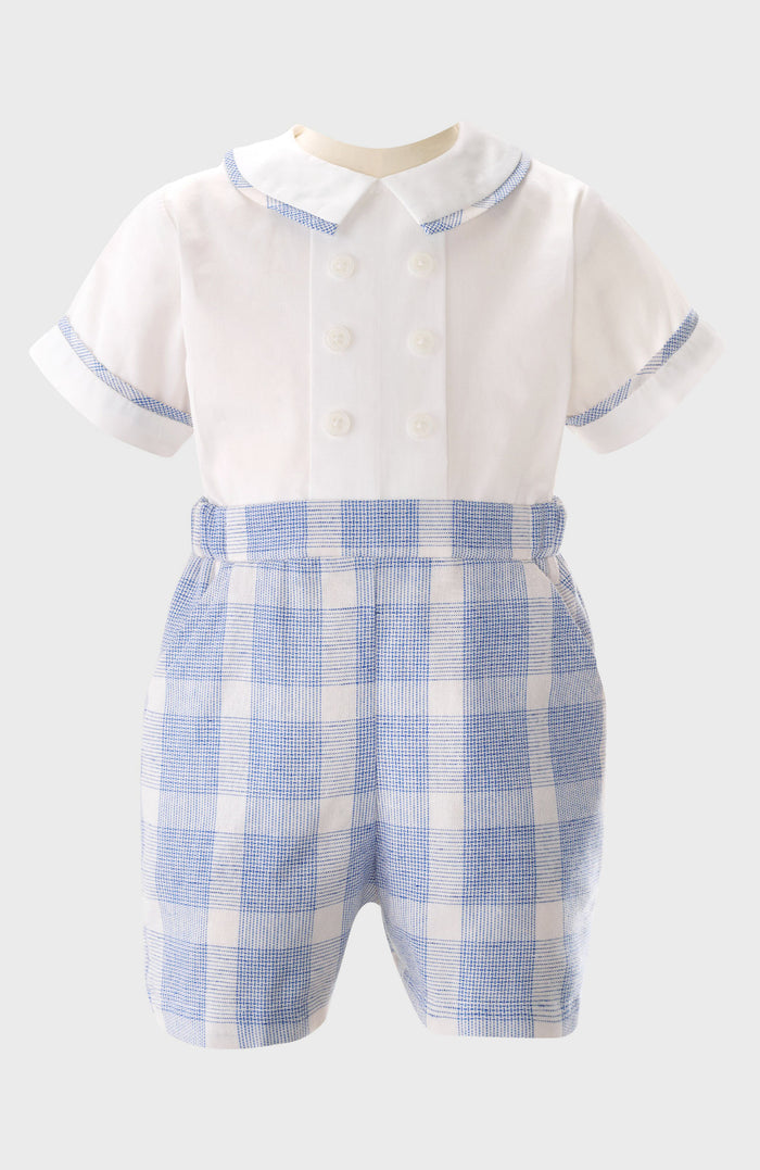 Rachel Riley infant romper inspired by British children's wear, featuring a white short-sleeve double-breasted top with blue plaid trim, matching attached shorts, and a Peter Pan collar for classic style.