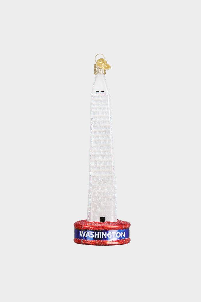 The Old World Christmas Washington Monument ornament features a red base labeled "Washington," making it a unique addition to your glass Christmas ornaments collection.